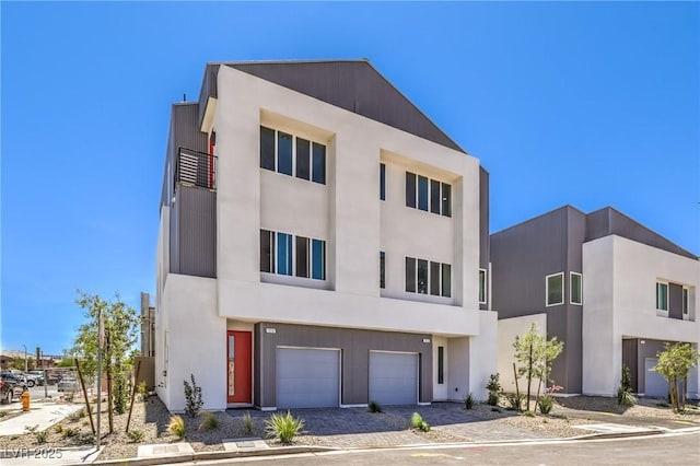 8629 Ensworth St Unit 114, Las Vegas, NV 89123 - view of front of property with a garage, stucco siding, and driveway