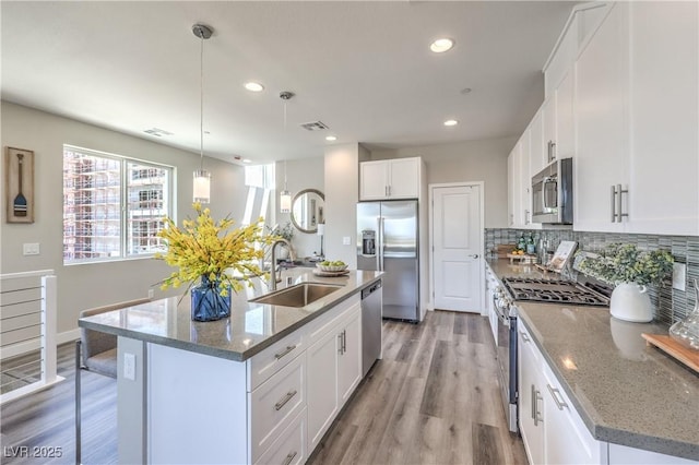 8629 Ensworth St Unit 114, Las Vegas, NV 89123 - kitchen with stainless steel appliances, recessed lighting, tasteful backsplash, white cabinetry, and light wood-style floors