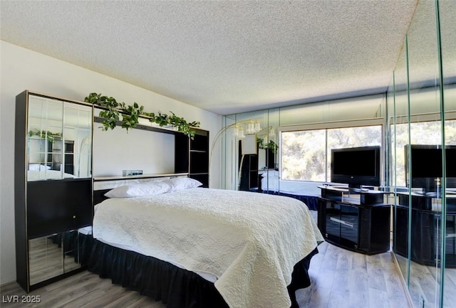 bedroom with a textured ceiling and wood finished floors