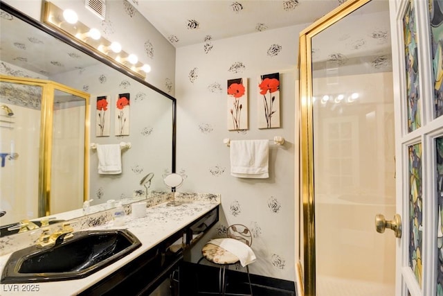 bathroom with visible vents, a shower stall, and vanity