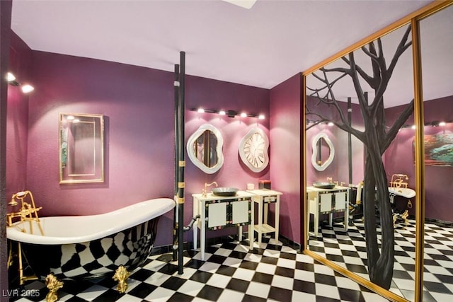 bathroom with tile patterned floors, vanity, and a freestanding tub