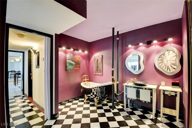 full bathroom with tile patterned floors, a freestanding bath, and vanity