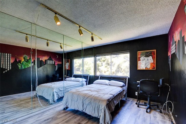 bedroom featuring a textured ceiling and wood finished floors