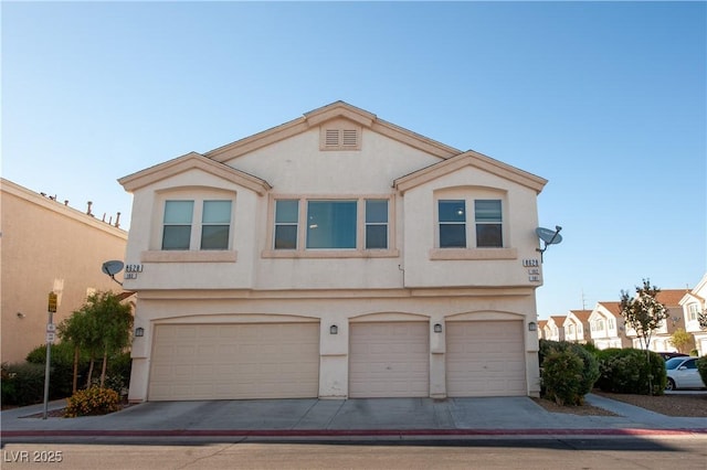 view of front facade with stucco siding, a garage, and driveway