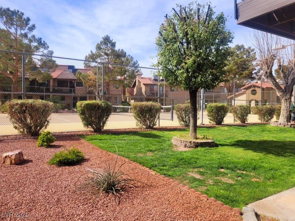 exterior space with a yard, fence, and a residential view