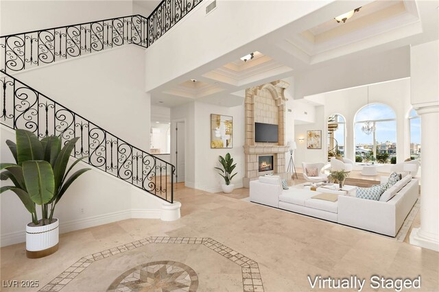 2660 Mirabella St, Henderson, NV 89052 - living area featuring visible vents, baseboards, a towering ceiling, stairs, and a fireplace