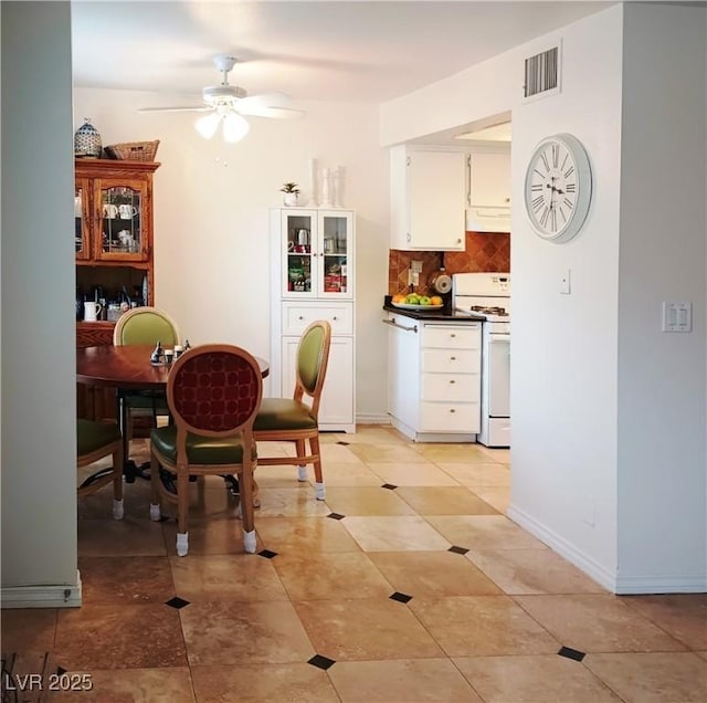 dining room featuring baseboards, a ceiling fan, visible vents, and light tile patterned flooring
