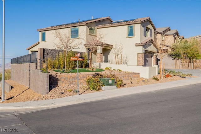 mediterranean / spanish home featuring stucco siding, roof mounted solar panels, and a tile roof