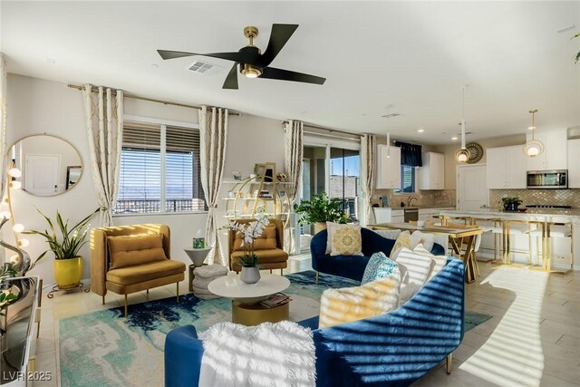 living area with visible vents and ceiling fan
