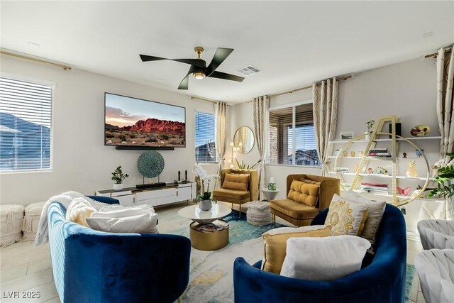 living area with light tile patterned flooring, visible vents, and ceiling fan