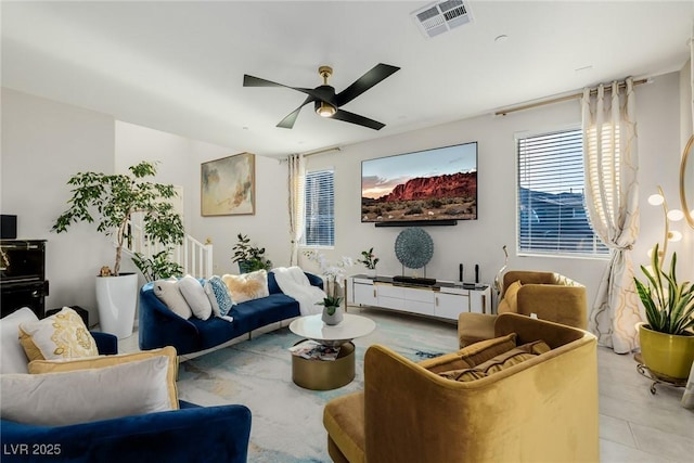 living area featuring visible vents, light tile patterned flooring, and a ceiling fan