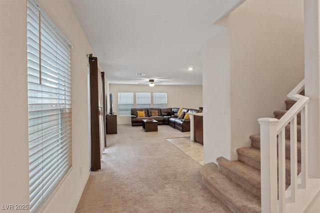 2945 Torreon Ln, Las Vegas, NV 89121 - living area with stairway, light colored carpet, visible vents, and ceiling fan