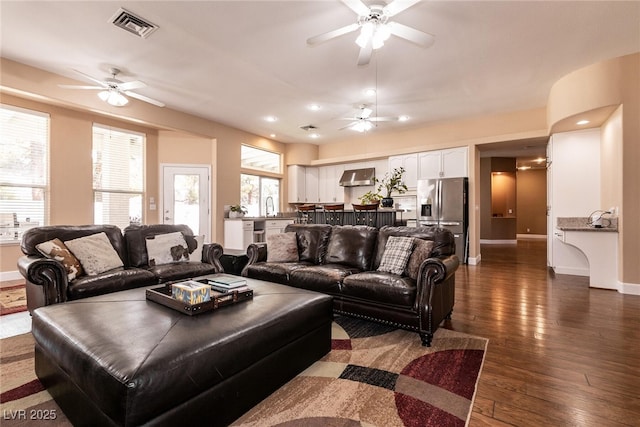living room featuring visible vents, baseboards, dark wood-style flooring, ceiling fan, and recessed lighting