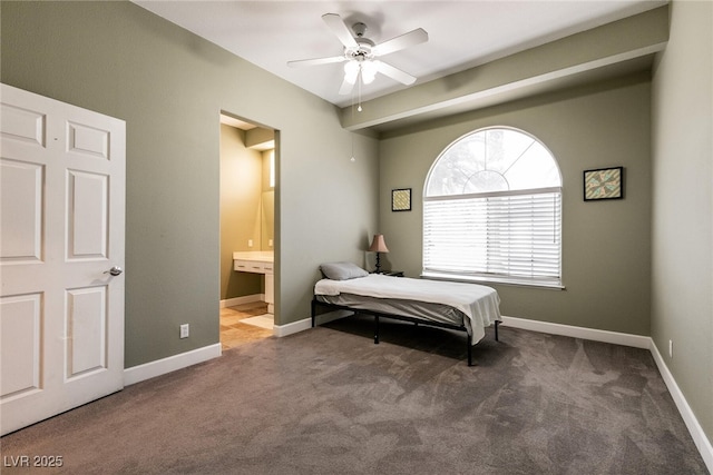 carpeted bedroom with ceiling fan, ensuite bathroom, and baseboards