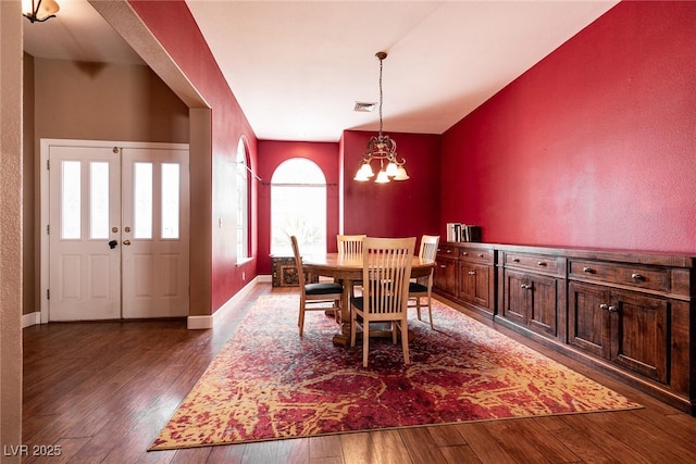 dining space with a chandelier, baseboards, wood-type flooring, and visible vents
