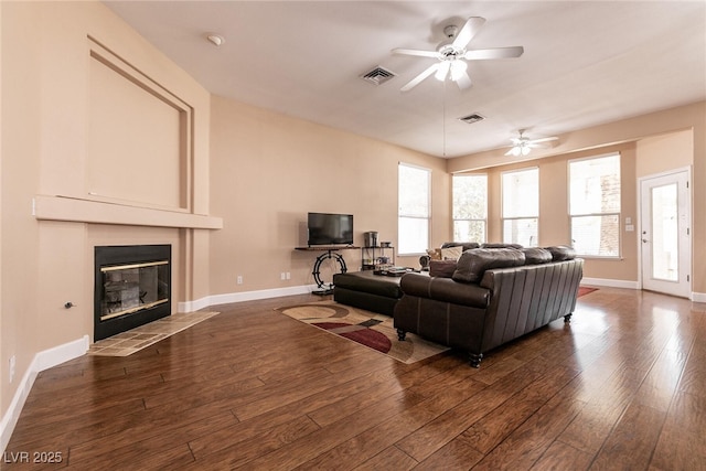 living area with visible vents, ceiling fan, and wood finished floors