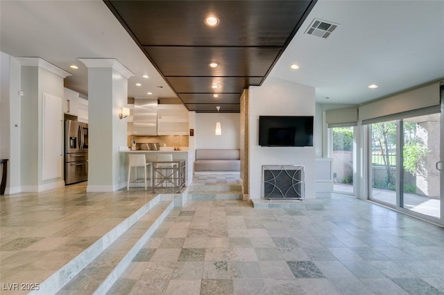 unfurnished living room featuring visible vents, a fireplace with raised hearth, recessed lighting, and baseboards