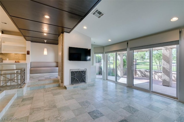 unfurnished living room featuring visible vents, recessed lighting, and baseboards