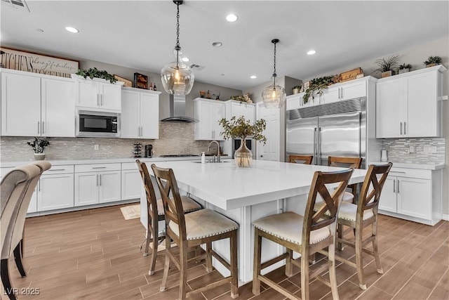 2833 Athena Hill Ct, Henderson, NV 89052 - kitchen with built in appliances, backsplash, wall chimney range hood, light countertops, and recessed lighting