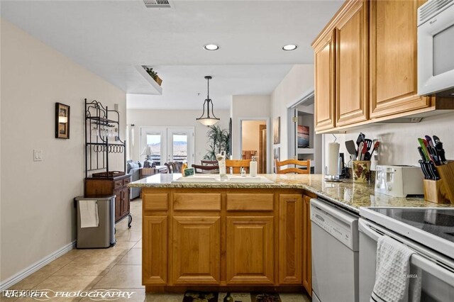 405 Paradise Pkwy Unit 170, Mesquite, NV 89027 - kitchen featuring hanging light fixtures, a peninsula, light tile patterned flooring, white appliances, and a sink