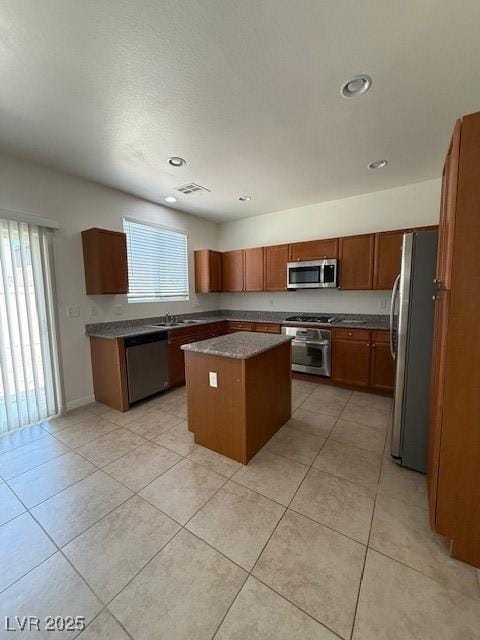 3104 Naggio Shores Ave, Las Vegas, NV 89141 - kitchen featuring stainless steel appliances, a center island, light tile patterned floors, recessed lighting, and brown cabinets