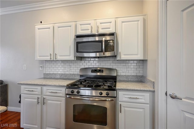 kitchen with stainless steel appliances, tasteful backsplash, white cabinets, and light countertops