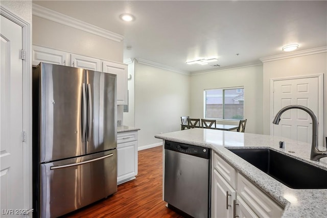 kitchen with a sink, crown molding, white cabinetry, and stainless steel appliances