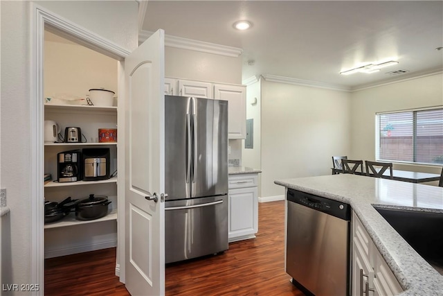 kitchen with light stone countertops, dark wood-type flooring, appliances with stainless steel finishes, and ornamental molding
