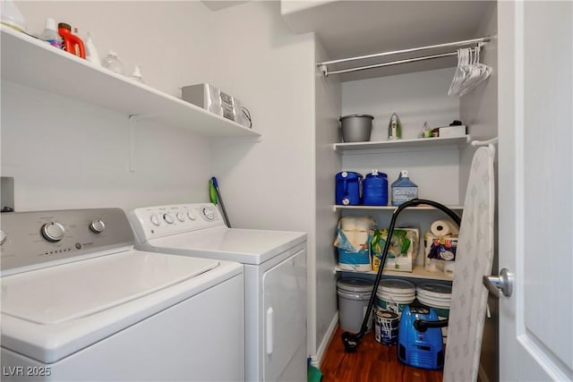 clothes washing area with laundry area, washing machine and dryer, and wood finished floors