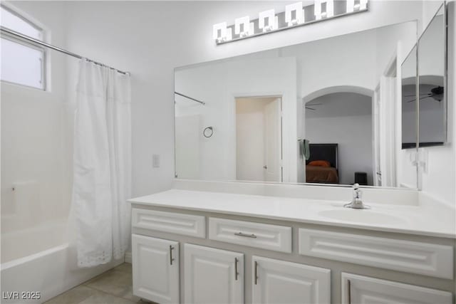 ensuite bathroom featuring vanity, shower / bathtub combination with curtain, ensuite bath, ceiling fan, and tile patterned floors