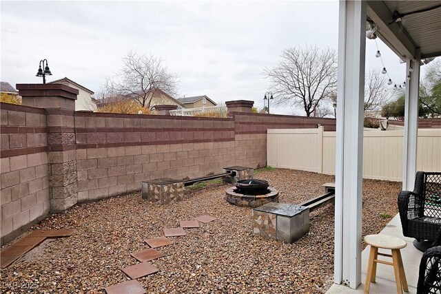 view of yard with a fire pit and a fenced backyard
