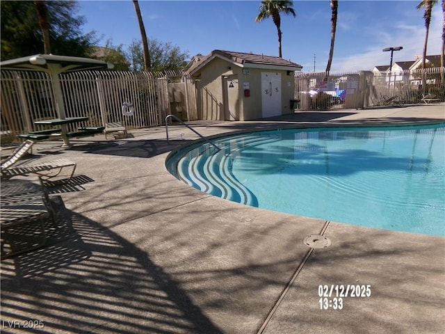 community pool with a patio and fence