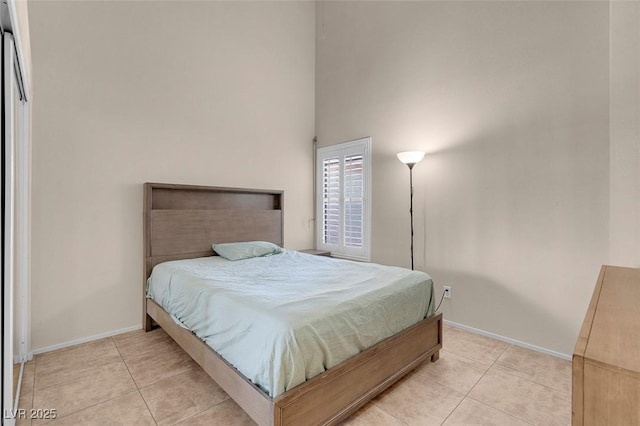 5000 Red Rock St Unit 241, Las Vegas, NV 89118 - bedroom with light tile patterned floors, baseboards, and a towering ceiling