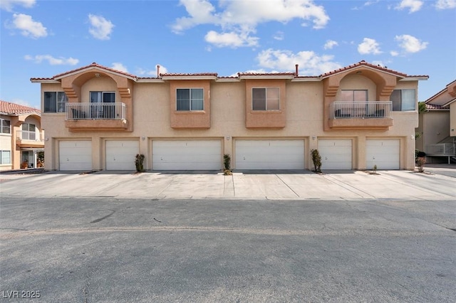 5000 Red Rock St Unit 241, Las Vegas, NV 89118 - townhome / multi-family property with stucco siding, an attached garage, a tile roof, and driveway