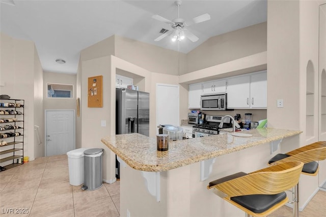 5000 Red Rock St Unit 241, Las Vegas, NV 89118 - kitchen featuring appliances with stainless steel finishes, a peninsula, a breakfast bar area, white cabinets, and ceiling fan