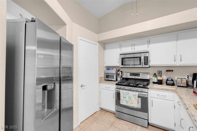 5000 Red Rock St Unit 241, Las Vegas, NV 89118 - kitchen featuring appliances with stainless steel finishes, light tile patterned floors, white cabinetry, vaulted ceiling, and light stone countertops