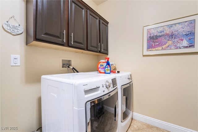 2246 Cassatt Dr, Henderson, NV 89074 - laundry area with washer and clothes dryer, cabinet space, baseboards, and light tile patterned flooring