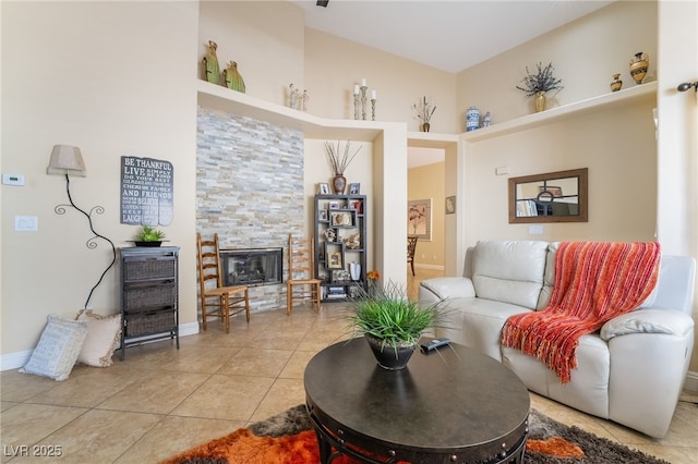 2246 Cassatt Dr, Henderson, NV 89074 - living room featuring light tile patterned floors, baseboards, and a glass covered fireplace