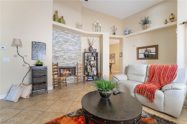 2246 Cassatt Dr, Henderson, NV 89074 - living room featuring a glass covered fireplace, light tile patterned flooring, and baseboards