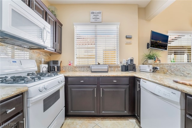 2246 Cassatt Dr, Henderson, NV 89074 - kitchen featuring tasteful backsplash, dark brown cabinetry, light tile patterned floors, light stone counters, and white appliances