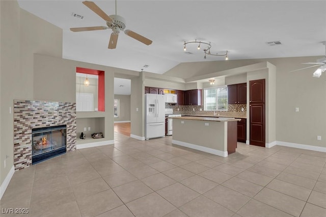 8217 Ashkum Ave, Las Vegas, NV 89149 - kitchen featuring white appliances, lofted ceiling, ceiling fan, open floor plan, and light tile patterned floors