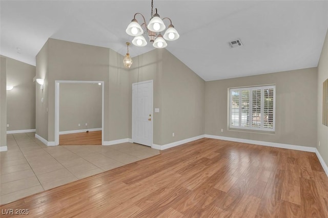 8217 Ashkum Ave, Las Vegas, NV 89149 - unfurnished living room featuring a chandelier, wood finished floors, baseboards, and vaulted ceiling