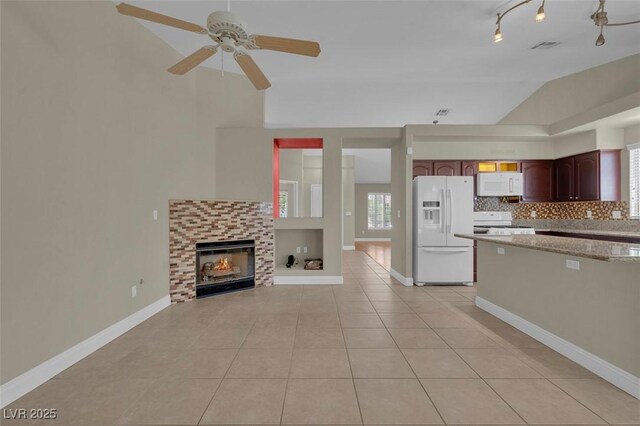 8217 Ashkum Ave, Las Vegas, NV 89149 - kitchen featuring white appliances, light tile patterned floors, a ceiling fan, lofted ceiling, and decorative backsplash