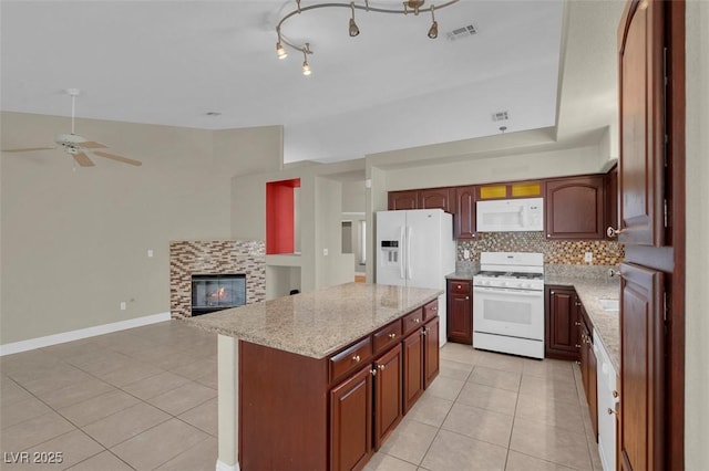 8217 Ashkum Ave, Las Vegas, NV 89149 - kitchen featuring white appliances, light tile patterned flooring, a tile fireplace, and decorative backsplash
