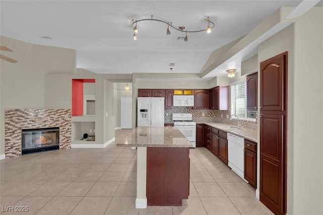 8217 Ashkum Ave, Las Vegas, NV 89149 - kitchen with white appliances, a sink, a kitchen island, light tile patterned floors, and light stone counters