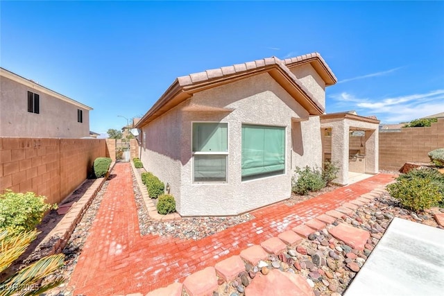 2528 Flodden St, Henderson, NV 89044 - view of side of property featuring a fenced backyard, stucco siding, and a patio area