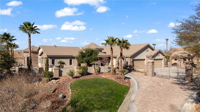 view of front of home with a tiled roof, stone siding, driveway, and fence