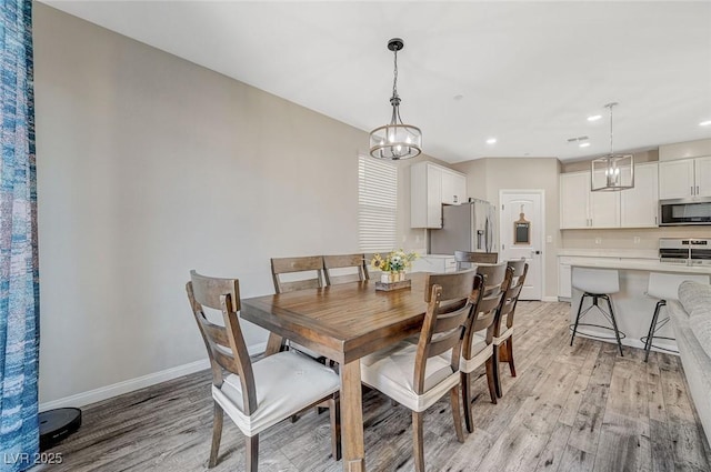 dining space with light wood finished floors, a chandelier, recessed lighting, and baseboards