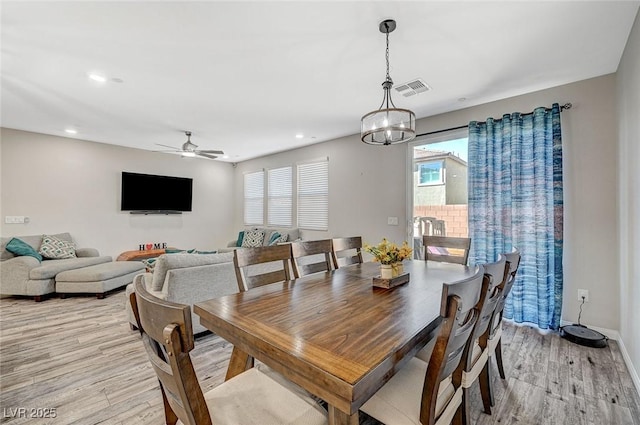 dining space with light wood finished floors, visible vents, ceiling fan with notable chandelier, and recessed lighting