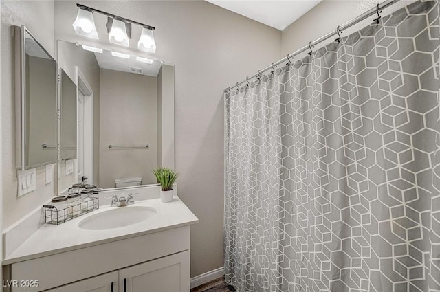 bathroom featuring curtained shower, toilet, and vanity